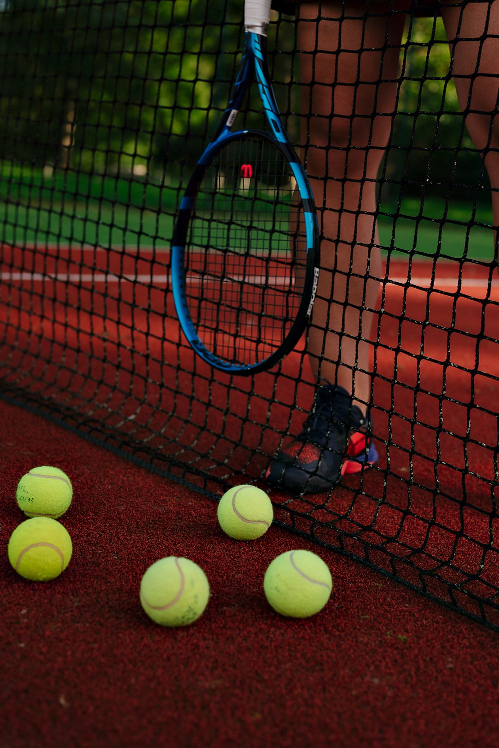 Tennis balls and racket at the net